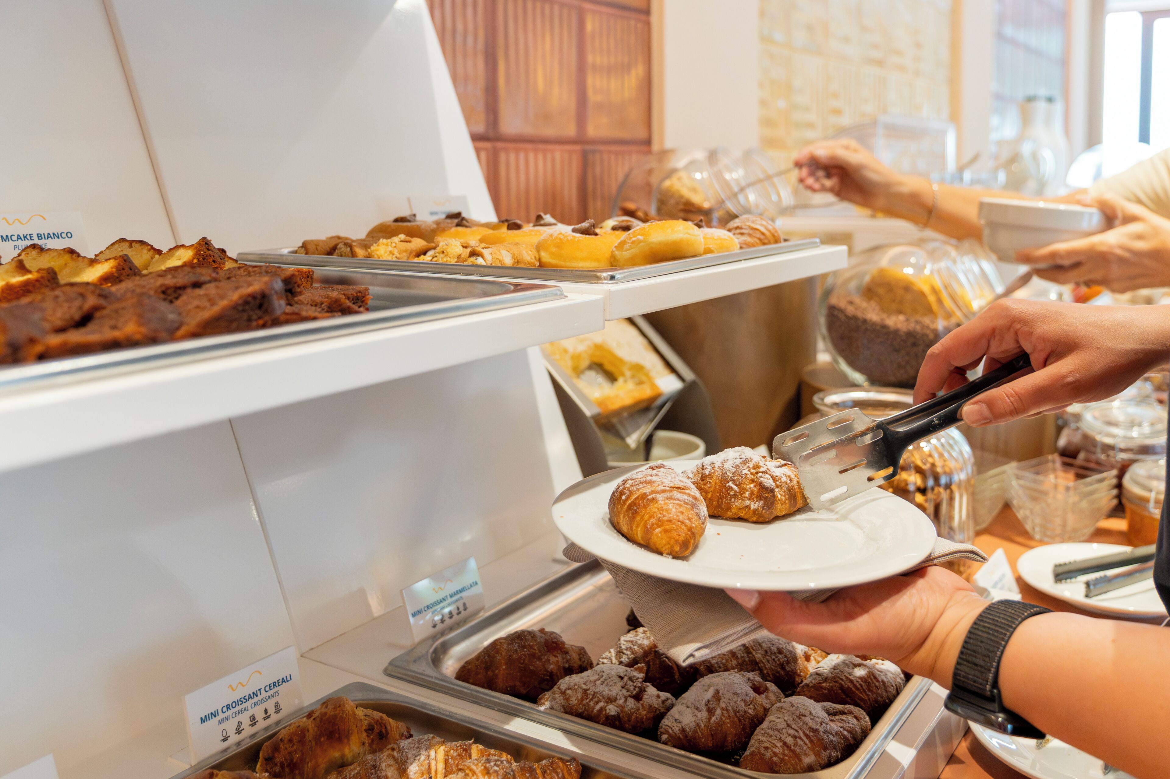 A buffet with various baked goods, including bread and pastries.