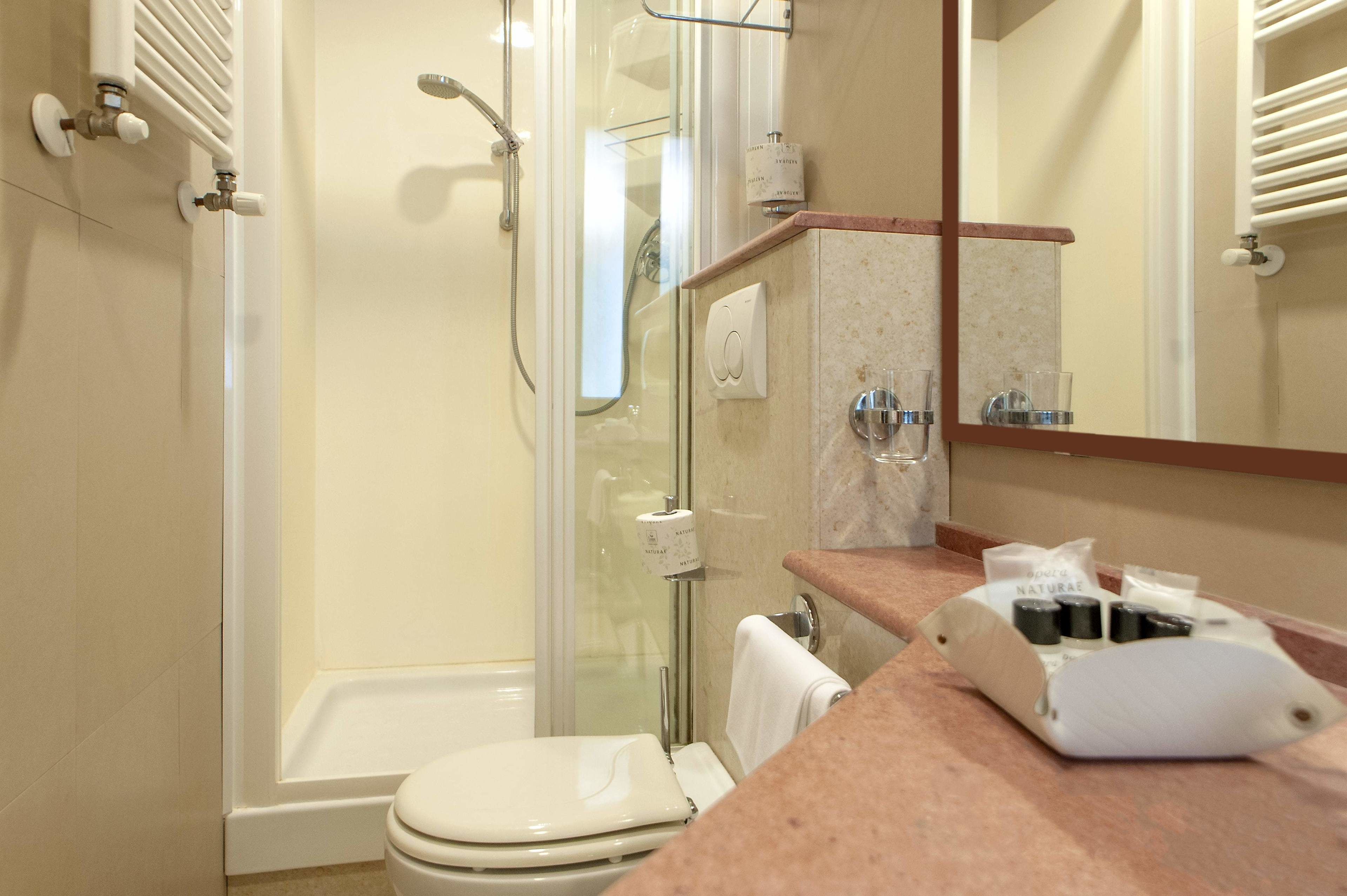 Une salle de bain avec une douche à parois de verre, des toilettes et un lavabo avec un plan de travail.