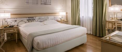 A neatly arranged hotel room with a large bed, bedside tables with lamps, a dresser, and a mirror.