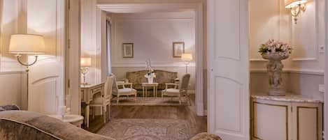 Un lobby de hotel clásico con un sofá cómodo, un área de comedor con mesa y sillas, y una estatua decorativa.