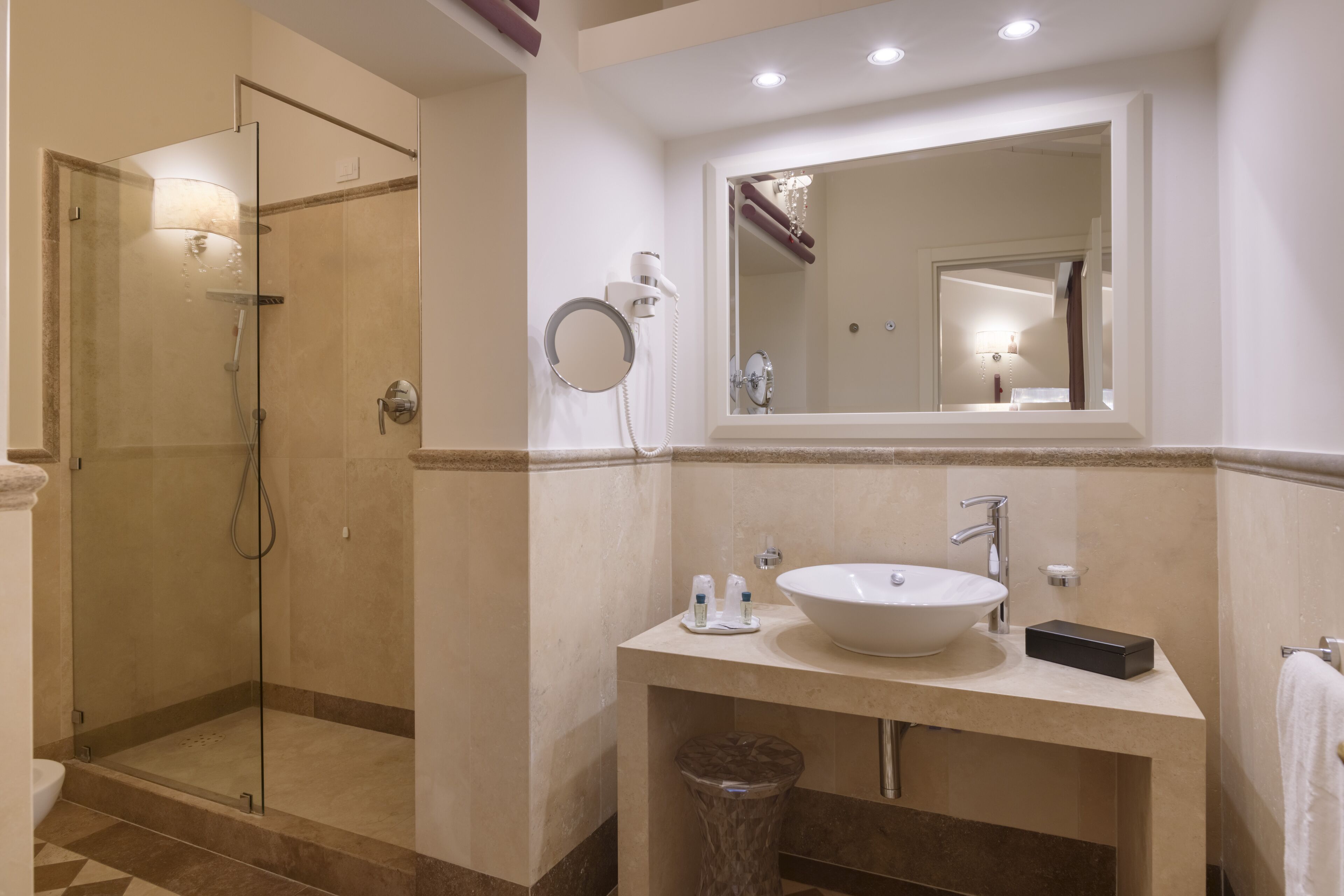 Une salle de bain avec une douche à parois de verre, un lavabo avec un miroir au-dessus et un porte-serviettes.