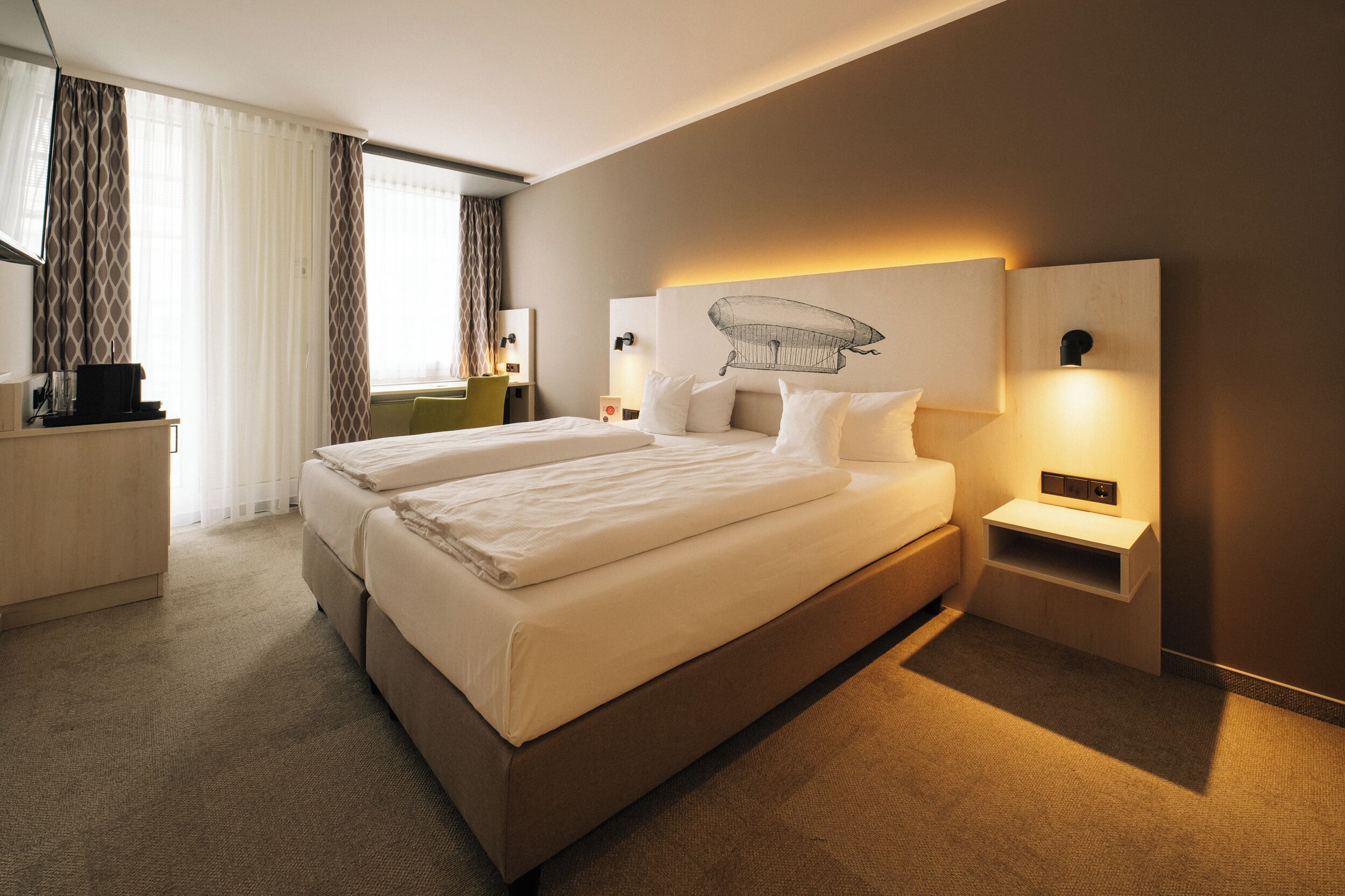 Une chambre d’hôtel avec un grand lit, un bureau, une chaise et une table de chevet.