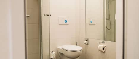A modern bathroom with a glass-enclosed shower, a toilet, and a bidet.