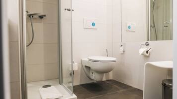 Ein modernes Badezimmer mit Duschkabine, Toilette und Waschbecken.
