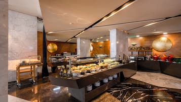 A buffet setup with a marble floor, a central serving counter, and a variety of food items.
