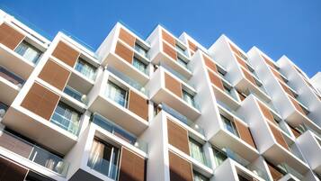 A multi-story building with a modern architectural design, featuring balconies and large windows.