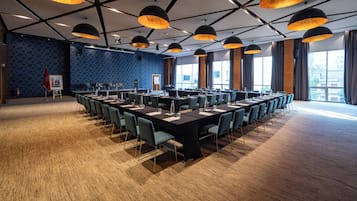 A conference room with a long table, multiple chairs, and large windows.