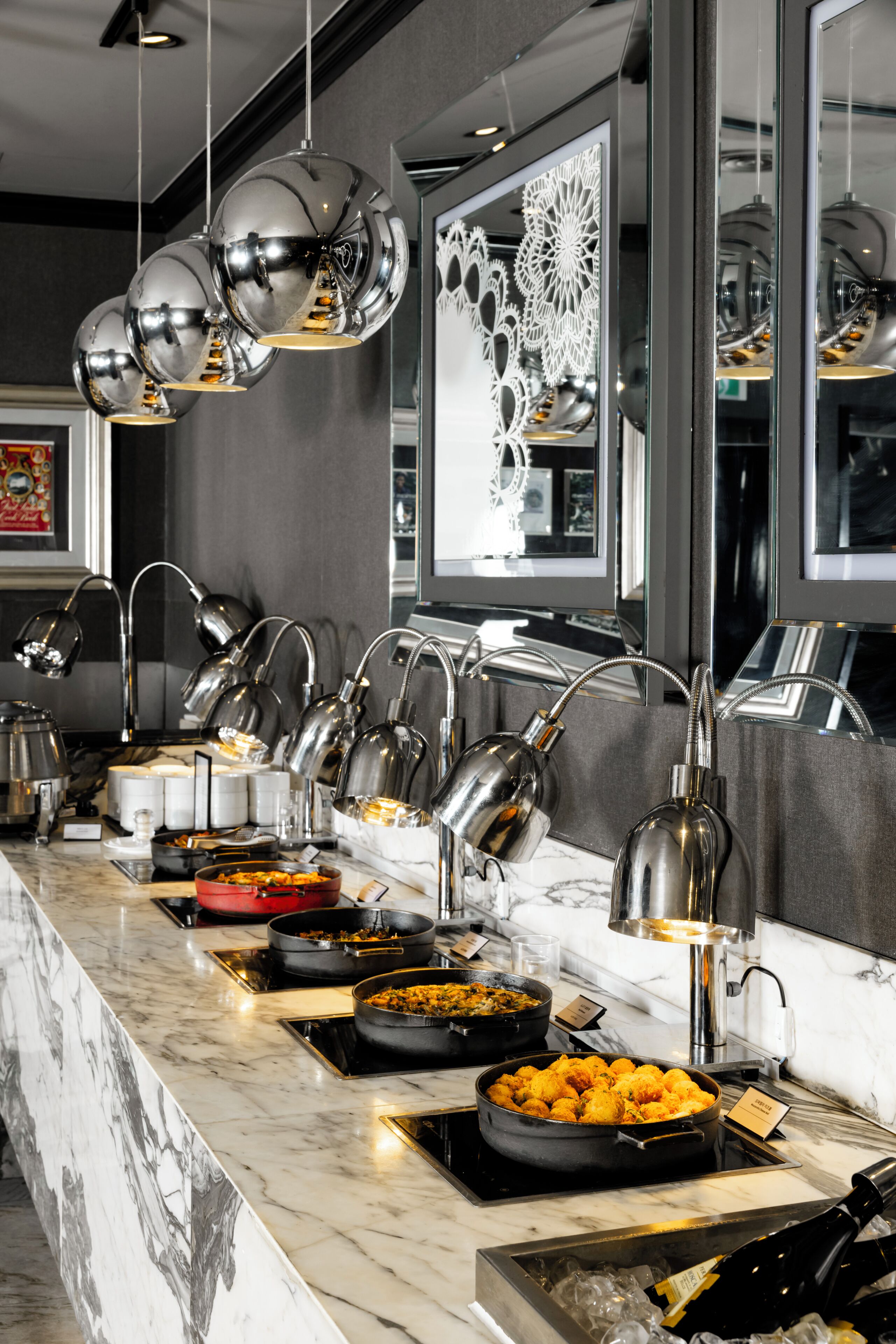 A buffet setup with various food stations, including a salad bar and a section with what appears to be fried items.
