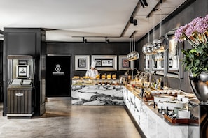 A modern hotel lobby with a marble reception desk, framed pictures on the wall, and a chef preparing food. - Kensington Hotel Yeouido Seoul (Seoul)