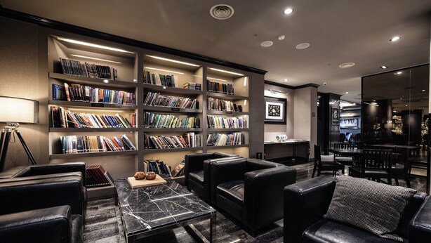 A modern library with leather seating, marble tables, and well-organized bookshelves. - Kensington Hotel Yeouido Seoul (Seoul)
