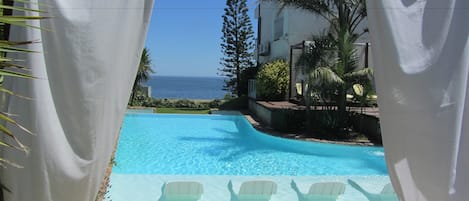 Piscine extérieure, parasols de plage, chaises longues