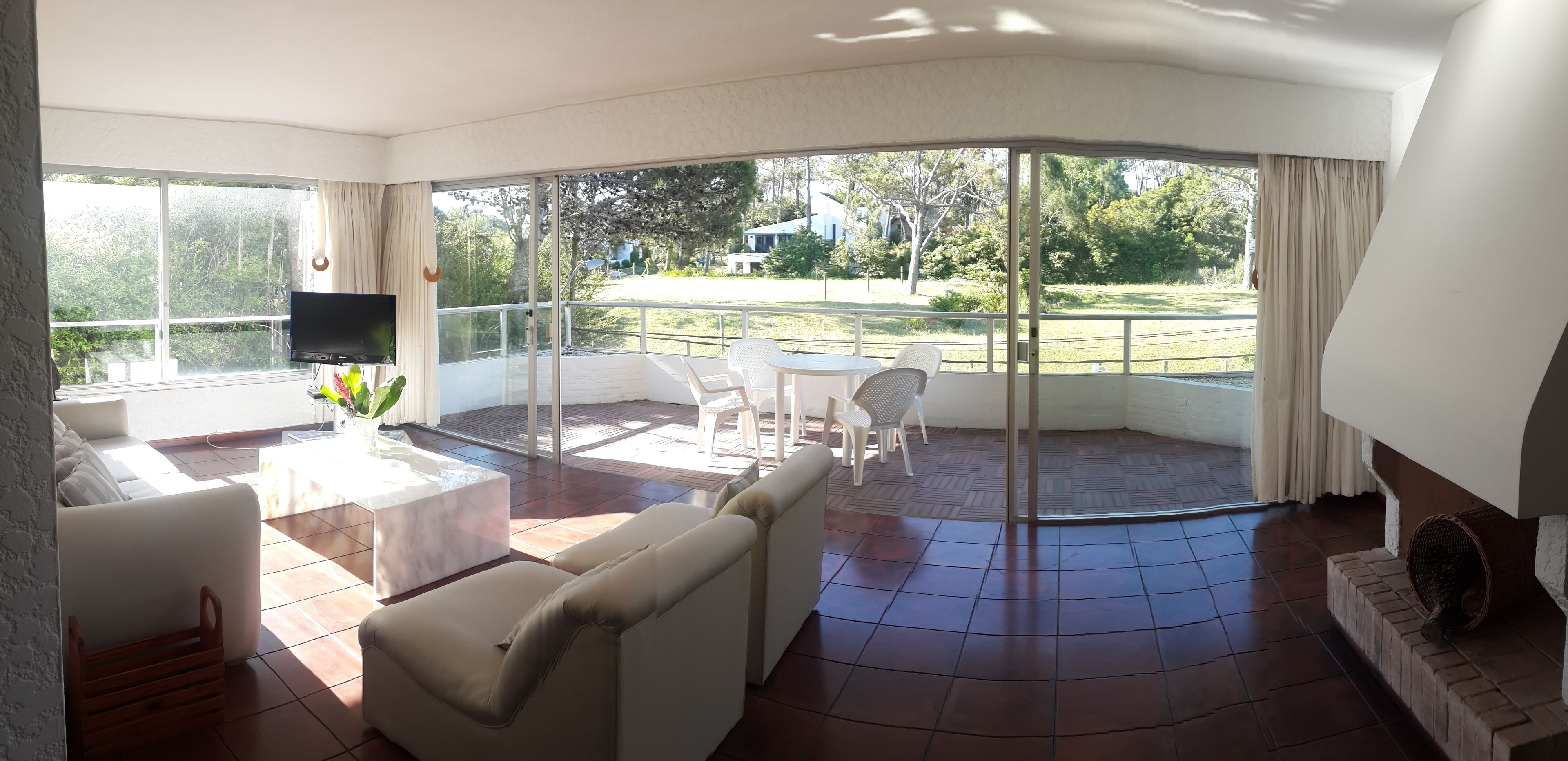 A modern living room with a large sliding glass door leading to an outdoor patio.