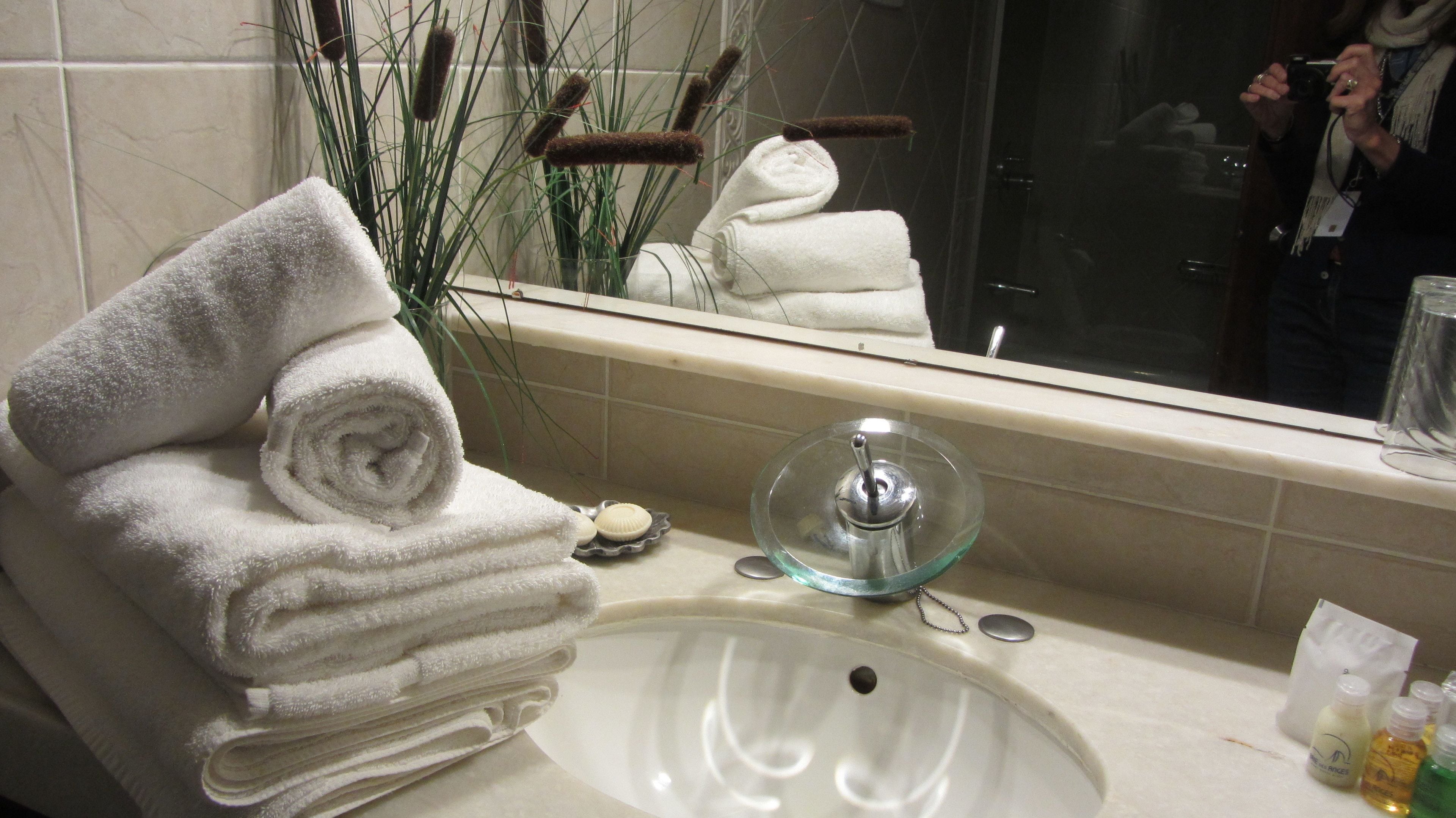 A bathroom with a sink, a mirror, and a towel rack.