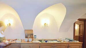 A kitchen with a long counter, equipped with various appliances and utensils, and two wall-mounted light fixtures. - Hotel Gasthof Moosleitner (Freilassing)