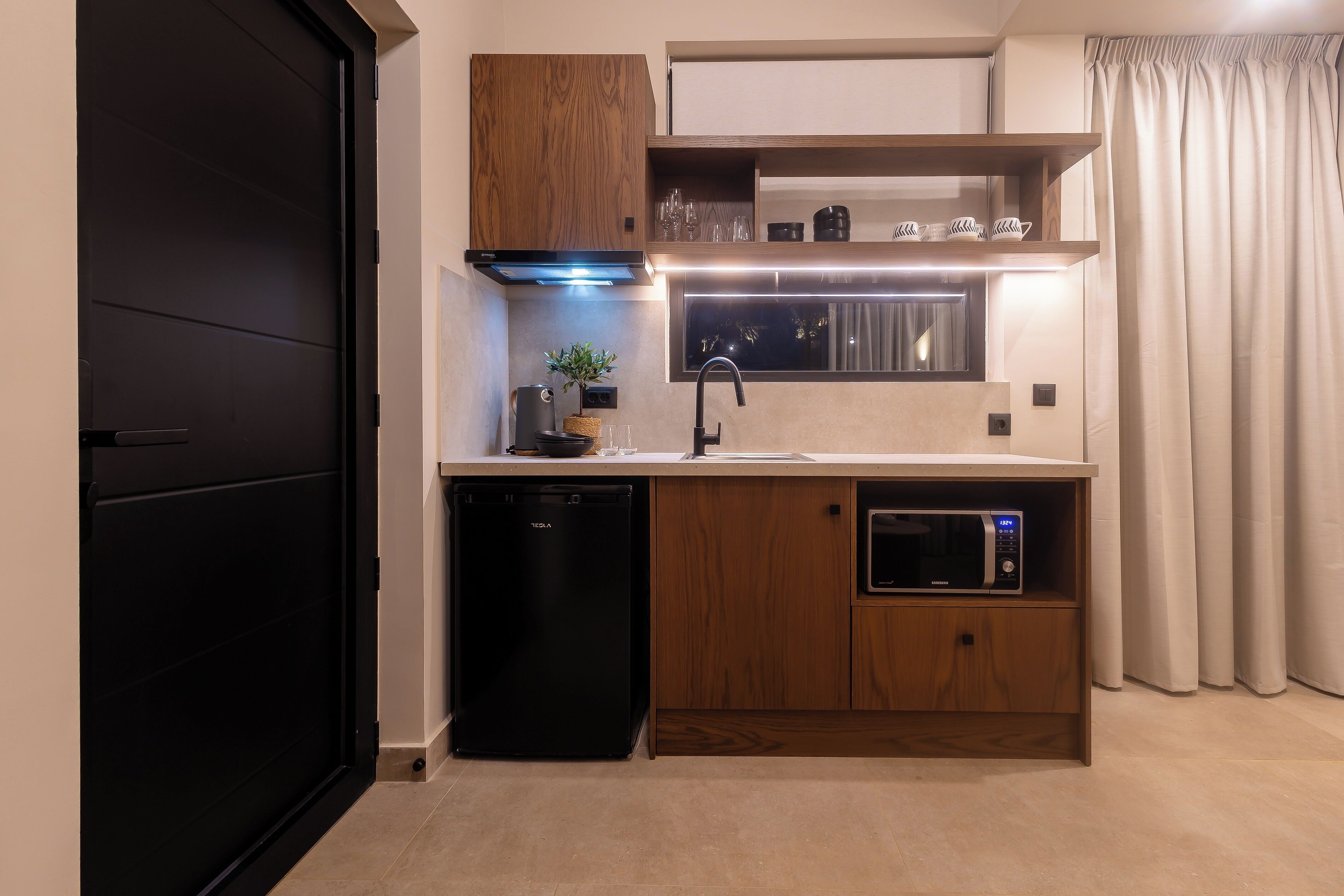 A compact kitchen with a dishwasher, microwave, and wooden cabinets.