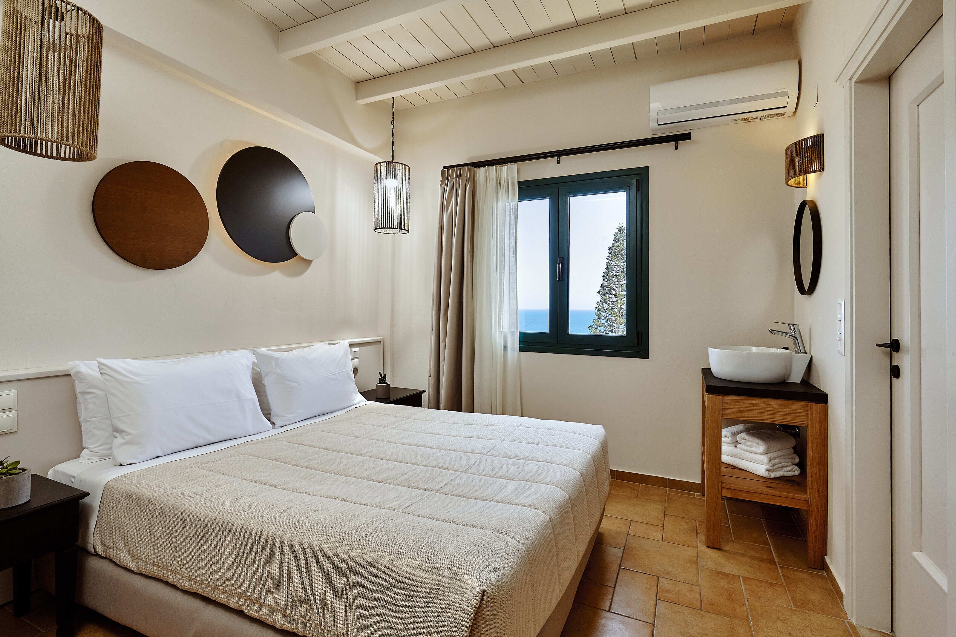 Habitació d'hotel amb un llit, un bany amb un lavabo i una finestra amb vistes.