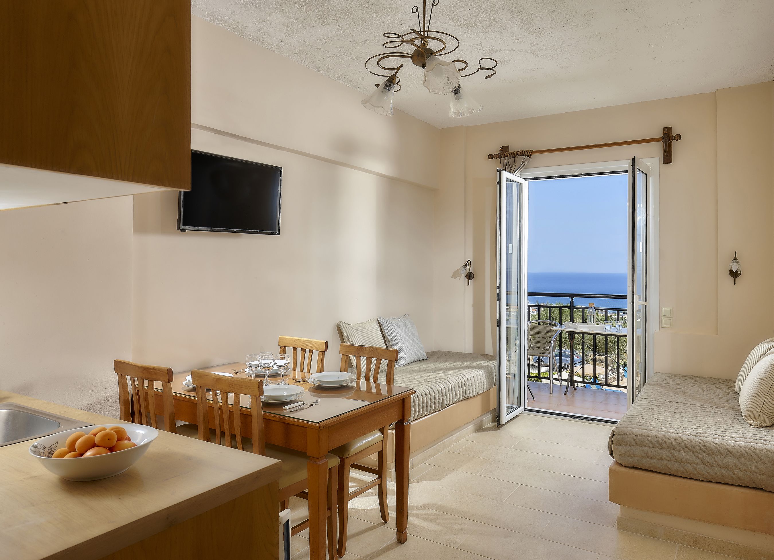 Eine moderne Küche mit Essbereich, einer Couch und einem Balkon mit Meerblick.