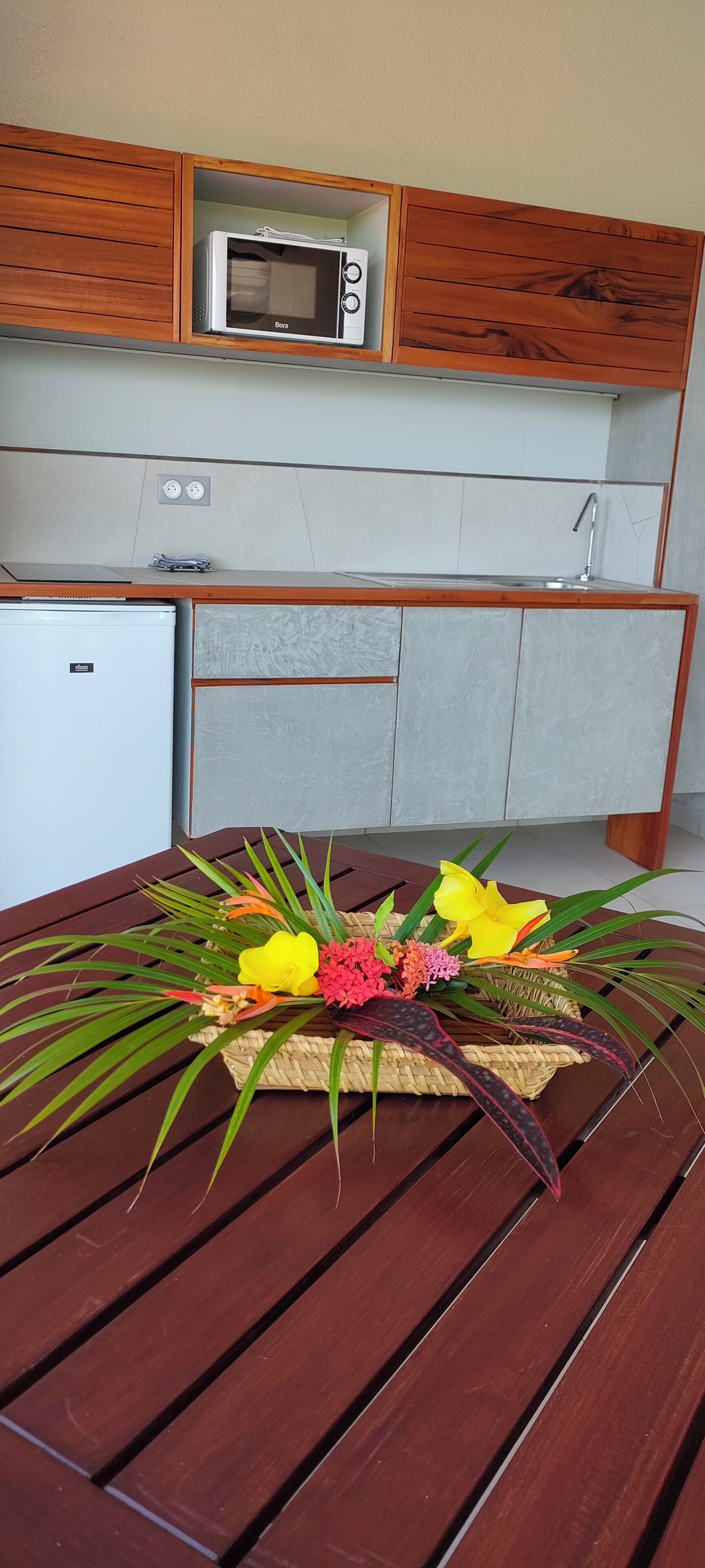 A kitchenette with a microwave, a small refrigerator, and a sink.
