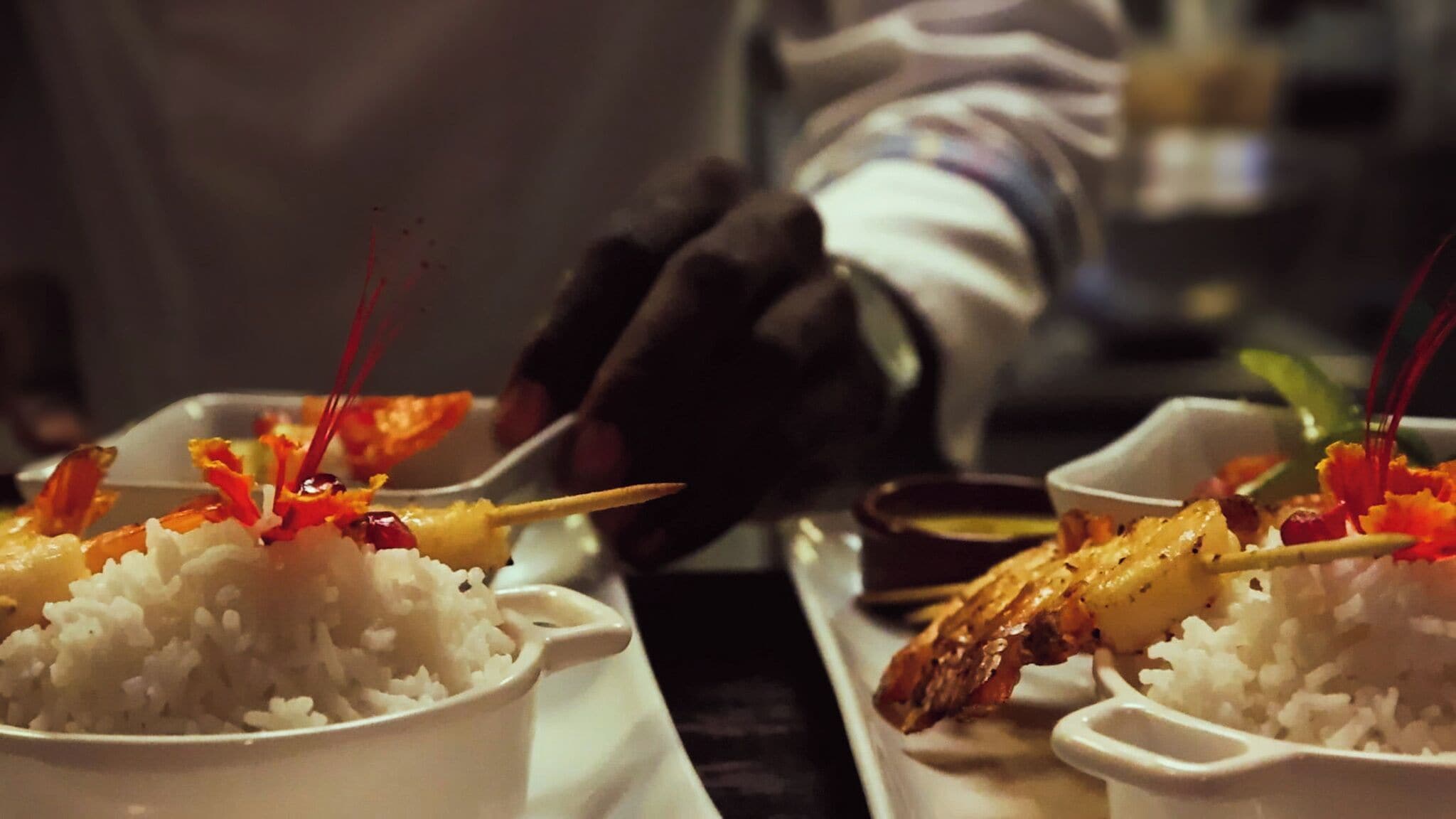 A person serving food, likely in a restaurant or dining setting.