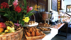 A buffet table with various food items and a decorative floral arrangement.