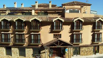 Un hotel con fachada de piedra, varios balcones y un cartel que indica que es un hotel spa.