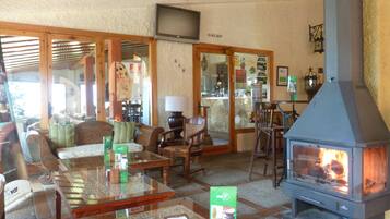 Una sala de estar acogedora con chimenea, asientos cómodos y una mesa de centro de vidrio.