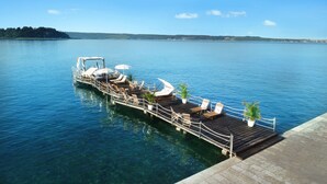 A docked boat with lounge chairs and umbrellas, a wooden deck, and a clear view of the water and distant land. - Grand Hotel Portorož – Lifeclass Hotels & Spa, Portorož (Piran)