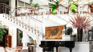 A spacious lobby with a grand staircase, a piano, and modern seating areas. - Grand Hotel Portorož – Lifeclass Hotels & Spa, Portorož (Piran)