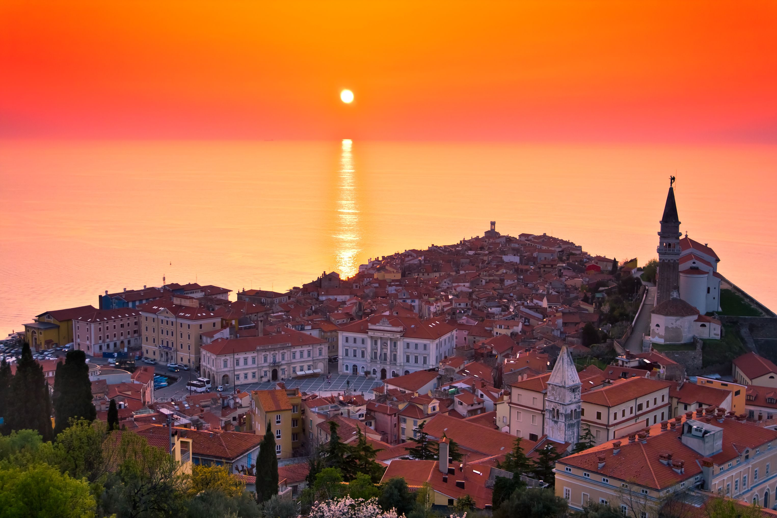 A coastal town with historic buildings and a prominent church on a hill.