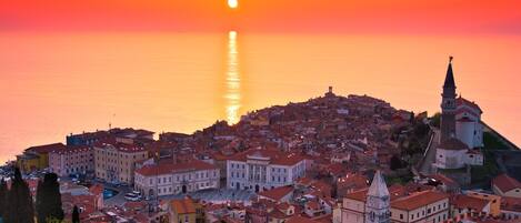 A coastal town with historic buildings and a prominent church on a hill.