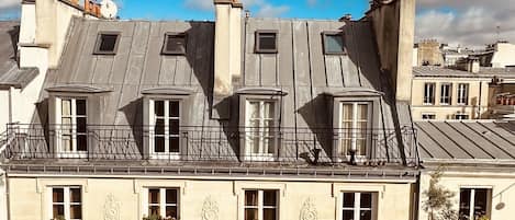 A multi-story building with a classic architectural style, featuring ornate window frames and balconies with metal railings.