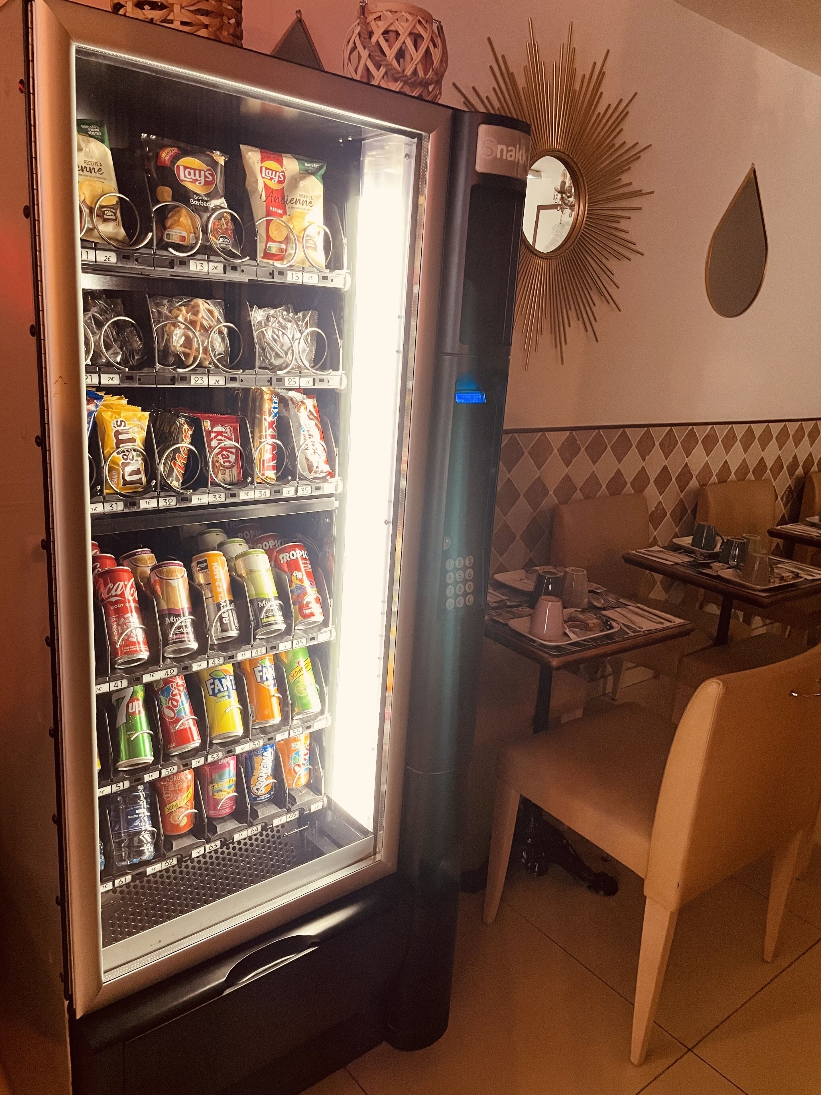 Máquina expendedora llena de aperitivos y bebidas en un restaurante.