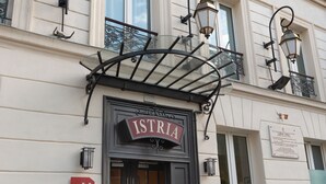 A hotel entrance with a sign reading "HOTEL ISTRIA" and a door labeled "H". - Hôtel Istria by Magna Arbor (Paris)