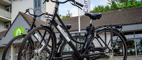 A bicycle parked in front of a building with a sign that reads "Campanile Hotel Restaurant".