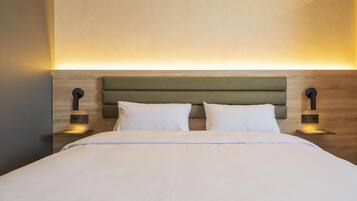 A neatly made bed with a wooden headboard and two bedside lamps.