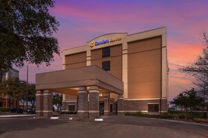 A hotel with a modern design, featuring a prominent sign for 'Comfort Suites'.