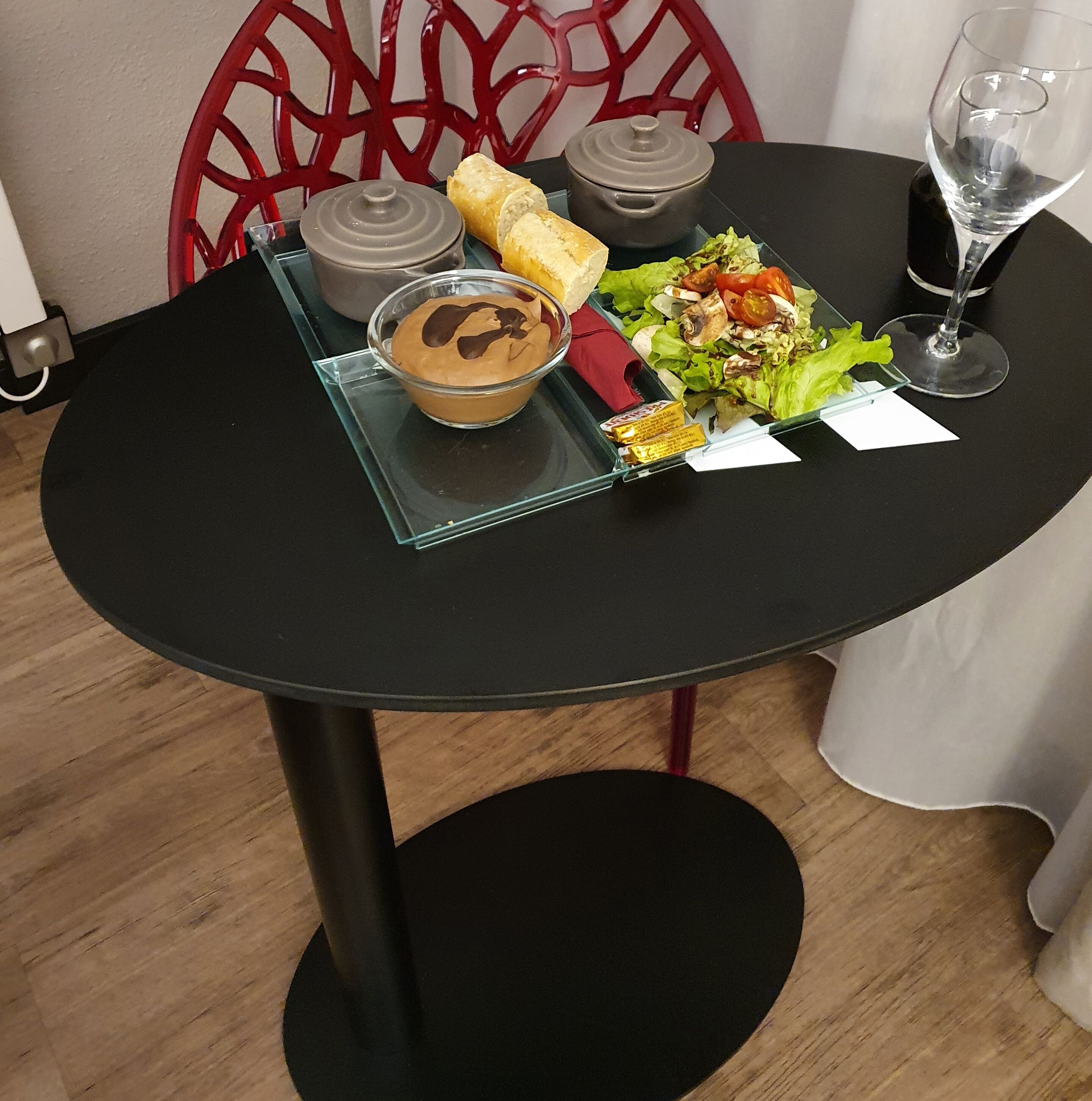 Une table dressée avec un repas composé d’un bol de soupe, d’un sandwich, d’une salade et d’un verre d’eau.