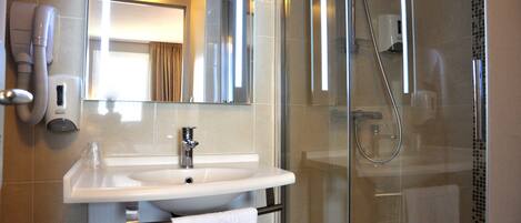 Une salle de bain moderne avec une douche à parois de verre, un lavabo blanc et un porte-serviettes.