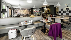 A modern restaurant with a bar area, seating, and a visible kitchen. - Ibis Styles Saint Brieuc Plerin (Plerin)