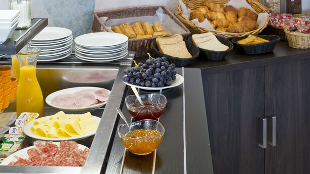 A breakfast buffet with various food items including bread, pastries, cheese, and fruits. - Comfort Hotel Linas Montlhery (Linas)