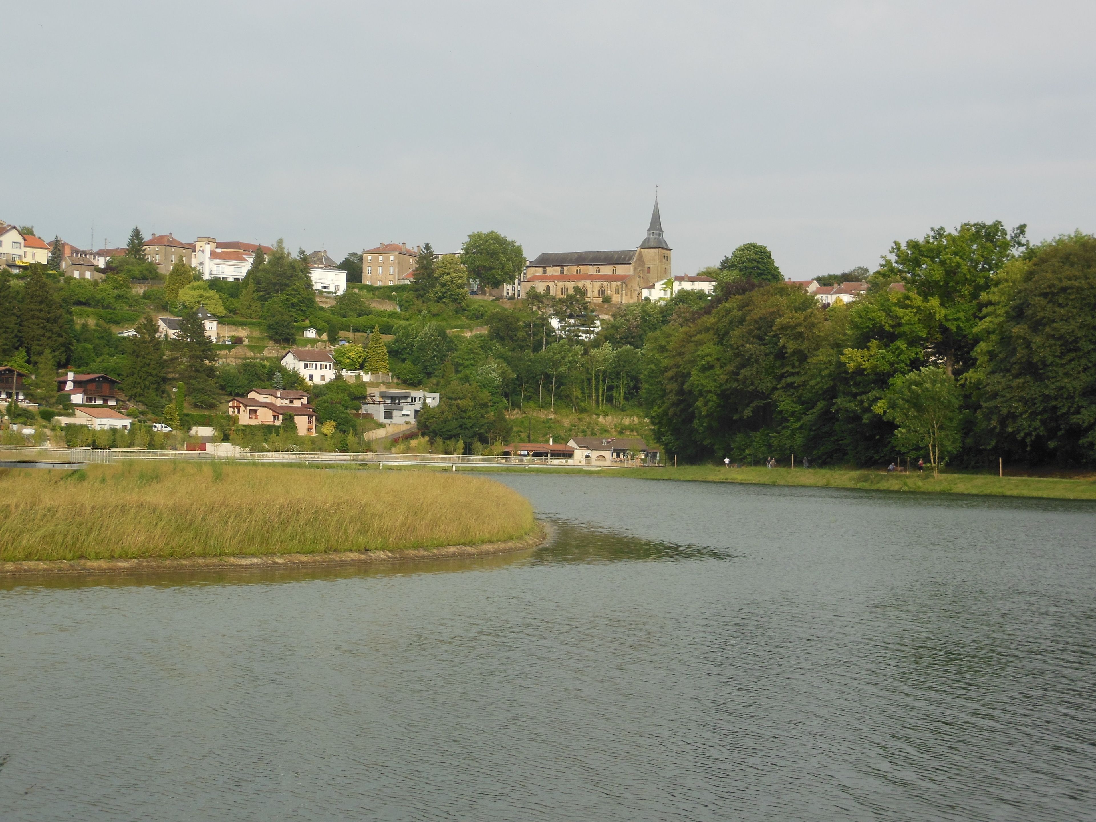 A lakeside view with a church and residential buildings.