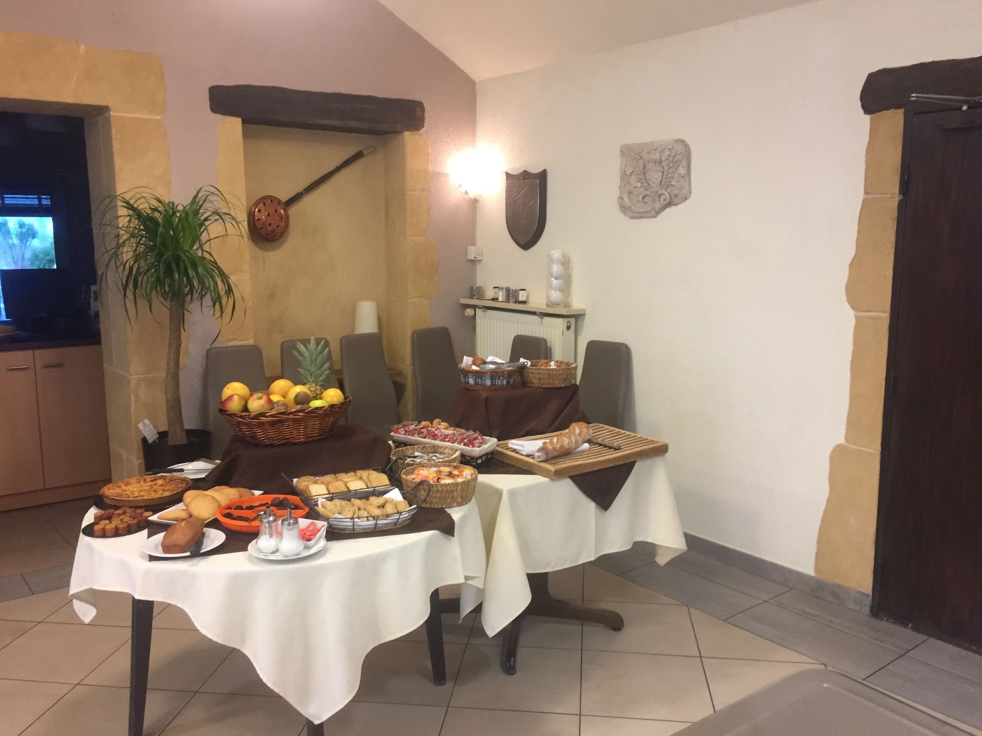 A dining area with a buffet table set up with various food items and a television in the background.