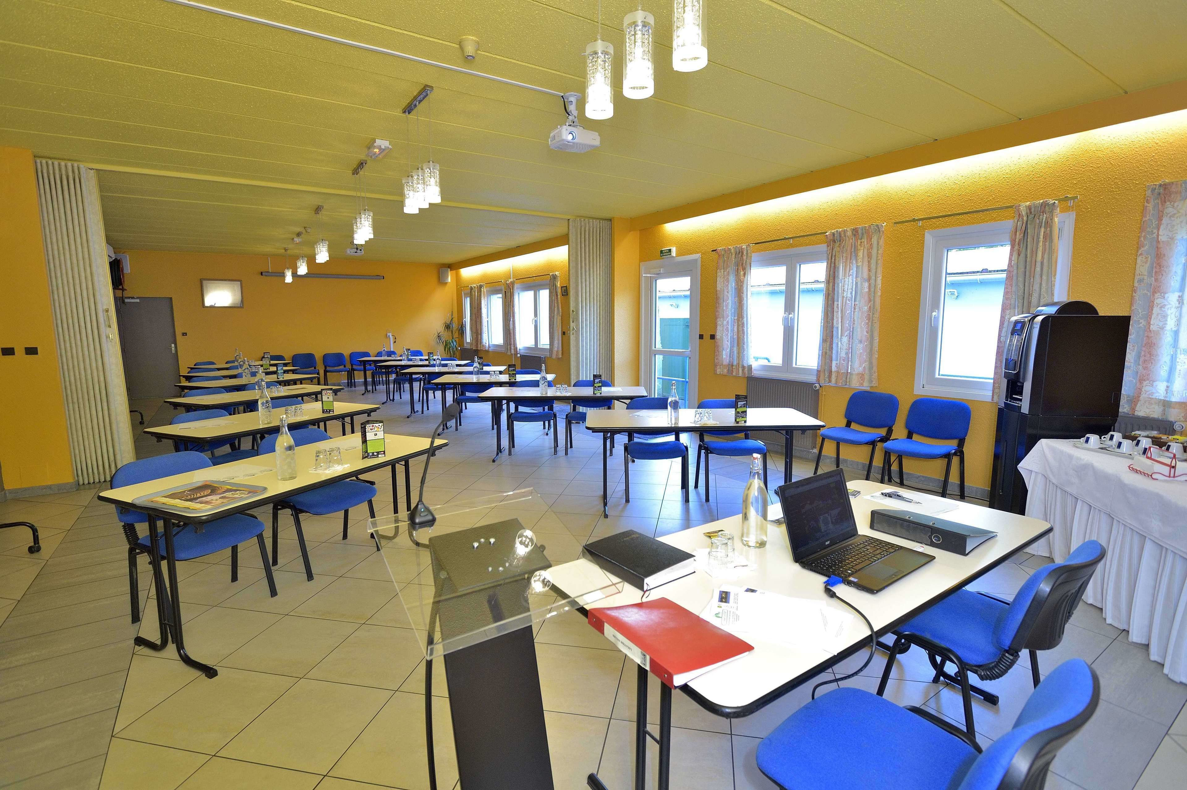 A classroom with tables, chairs, and a projector.