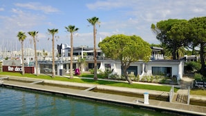A waterfront property with a marina, modern architecture, and a well-maintained garden. - Le Spinaker Boutique Hôtel Restaurant (Le Grau-Du-Roi)