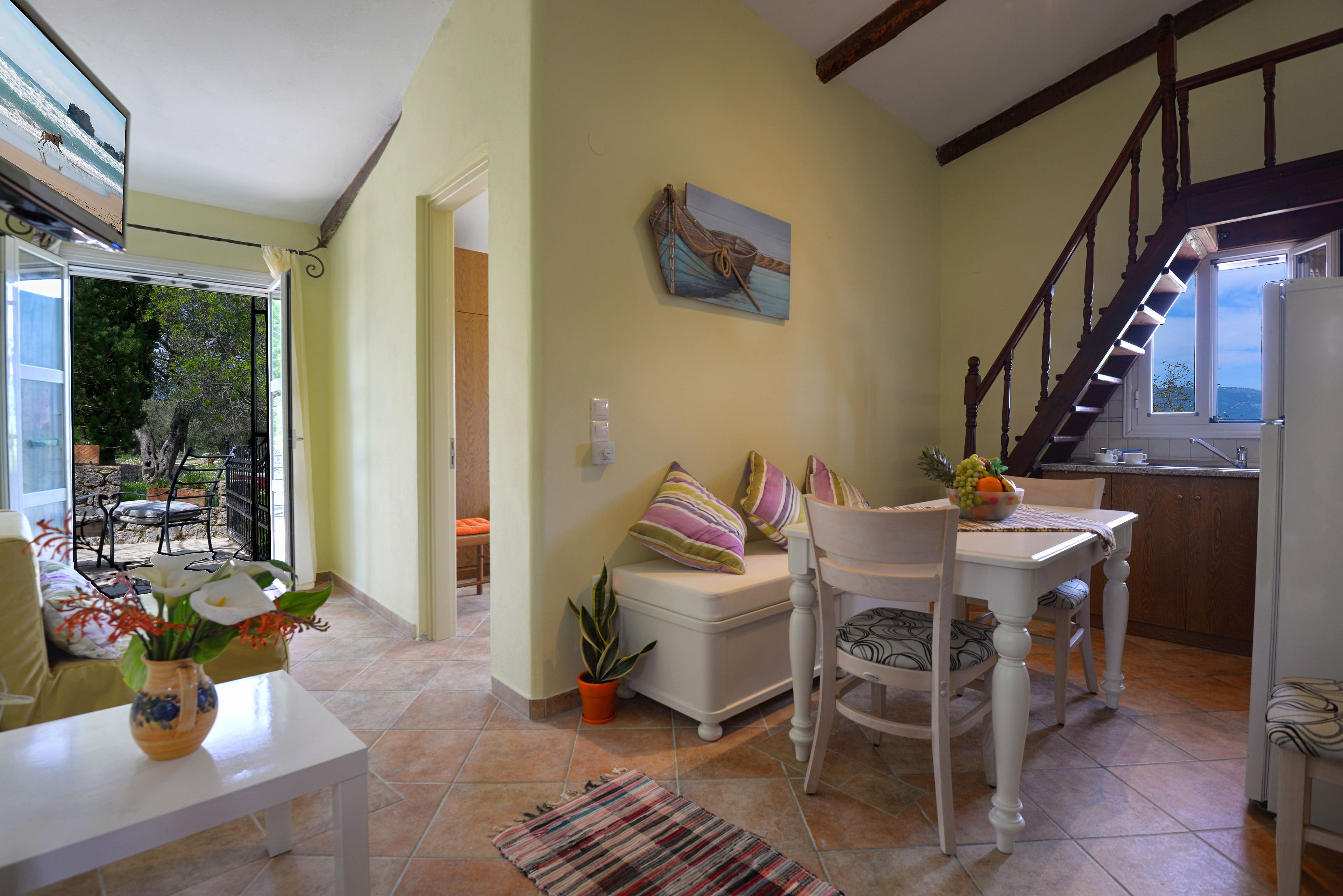 Una sala de estar acogedora con un sofá, una mesa de comedor y una escalera.