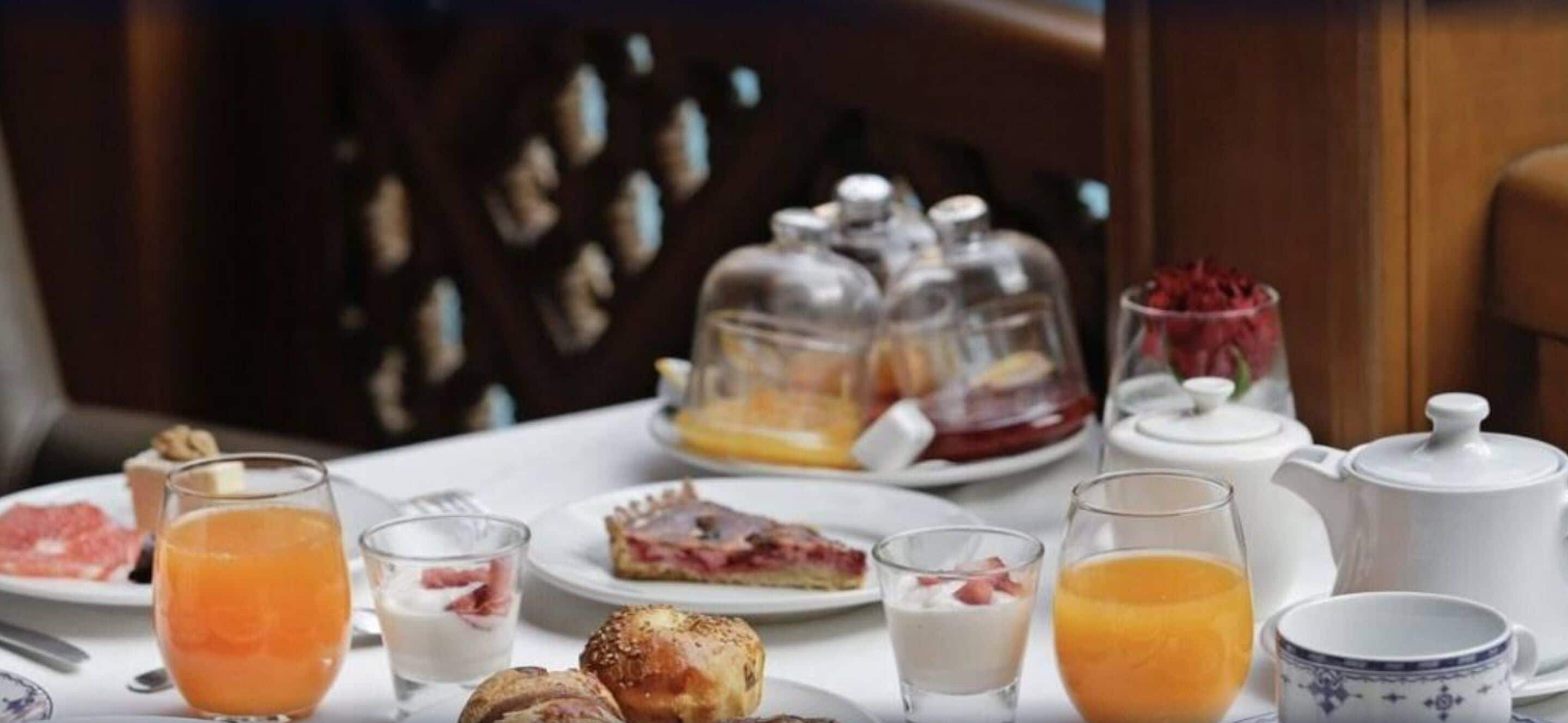 A breakfast setting with various food items and beverages on a table.