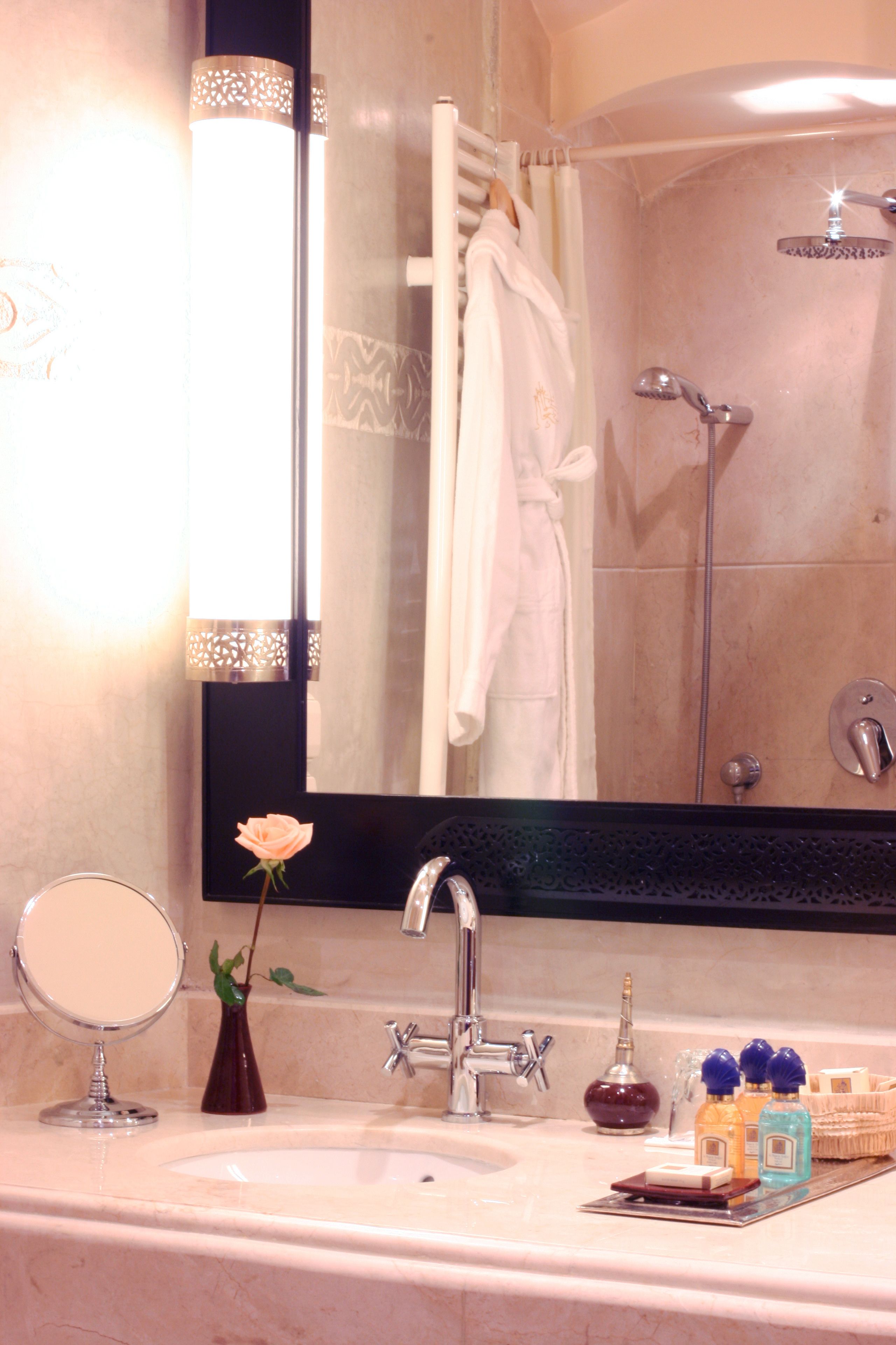 Un baño con lavamanos, espejo y ducha.