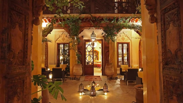 An ornate lobby with a central chandelier, seating areas, and a decorative archway. - La Maison Arabe Hotel, Spa and Cooking Workshops (Marrakech)