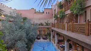 A courtyard with a pool, outdoor seating, and traditional architecture. - La Maison Arabe Hotel, Spa and Cooking Workshops (Marrakech)