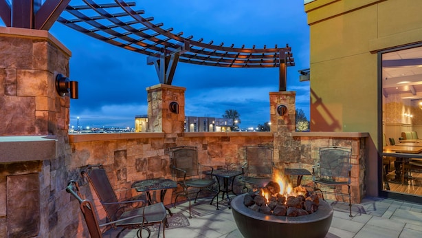 Une terrasse extérieure dotée d’un foyer, de murs en pierre et de mobilier d’extérieur.